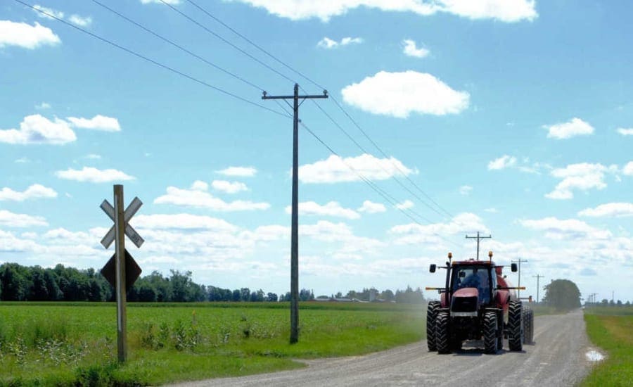 Tractor driving down road in Huron Shores Ontario Tractor driving down road in Huron Shores Ontario